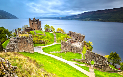 Urquhart Castle mit Dark Cloud Sky und Loch Ness im Hintergrund