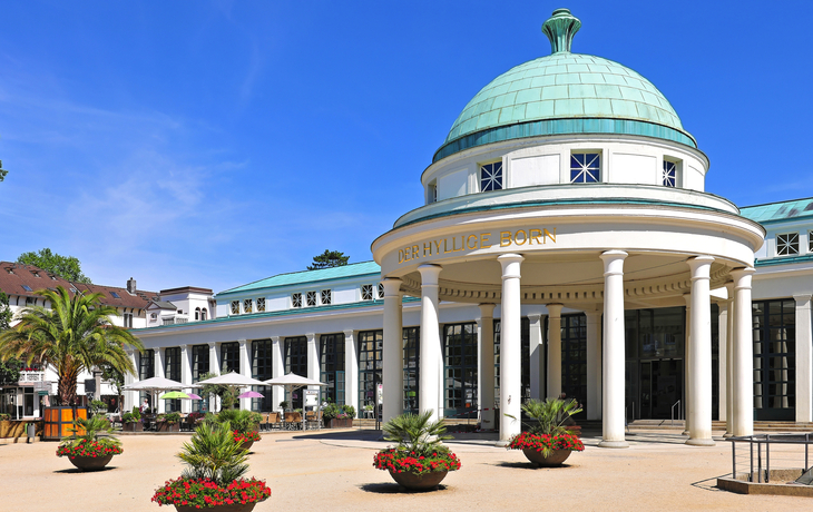 Klassische Architektur des Hyllige Born in Bad Pyrmont, umgeben von Blumenbeeten.
