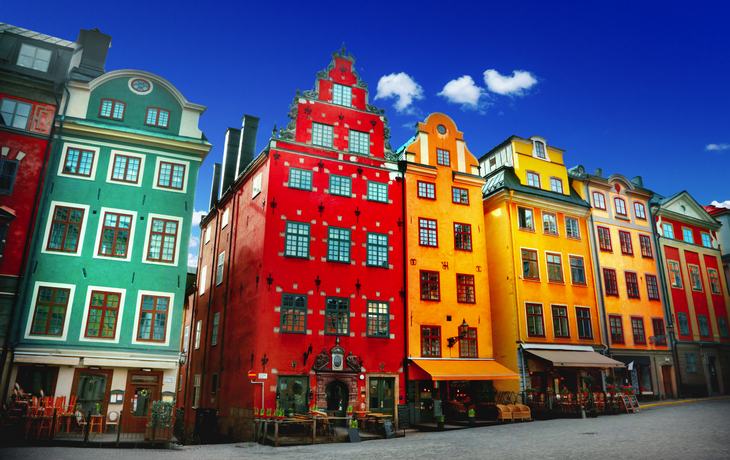 Bunte Fassaden historischer Gebäude in der Altstadt von Stockholm, Schweden, bei klarem Himmel.