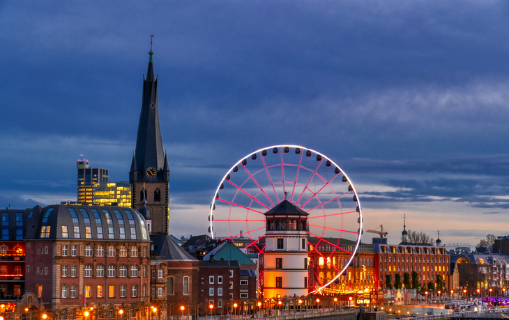 Skyline von Düsseldorf mit Riesenrad bei Abenddämmerung