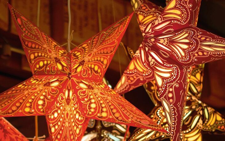 Bunte Papiersternlichter hängen von der Decke.