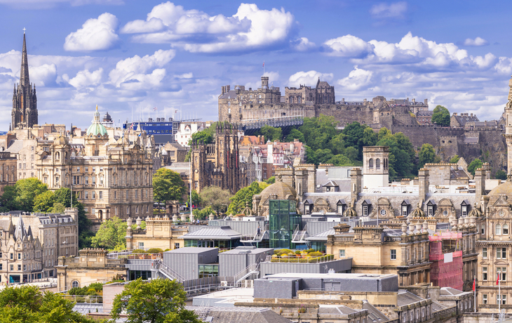 Panorama von Edinburgh mit mittelalterlicher Architektur und Schloss im Hintergrund.