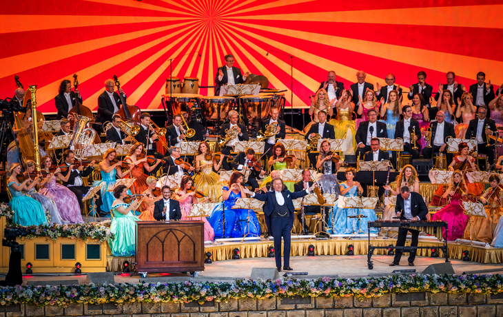 Andre Rieu spielt Geige auf der Bühne beim Konzert in Maastricht, Zuschauer im Hintergrund.