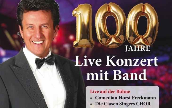 Ein Mann im Anzug vor Tourneeplakat mit Text 