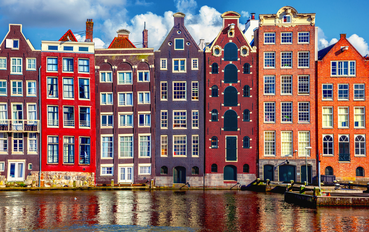 Häuser mit Giebelfassaden entlang eines Kanals in Amsterdam, Niederlande.
