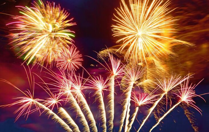 Feuerwerk am Nachthimmel mit bunten Explosionen und funkelnden Lichtern.