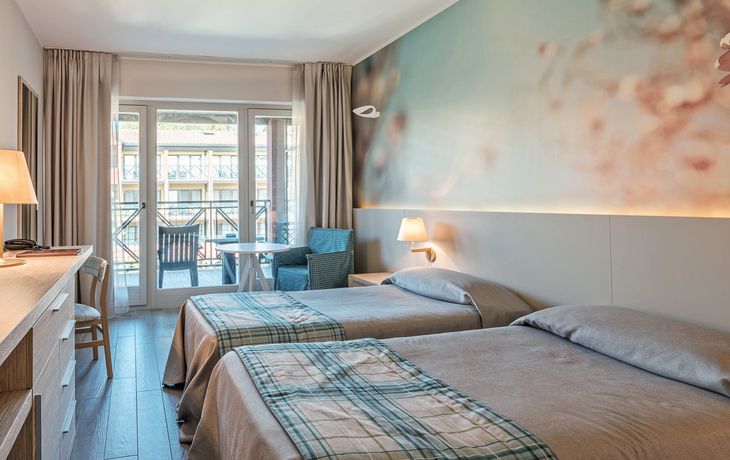Doppelzimmer mit Balkon, zwei Betten und Sitzbereich