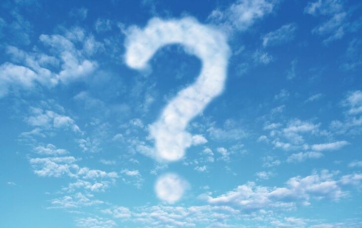 Wolken in Form eines Fragezeichens am blauen Himmel.
