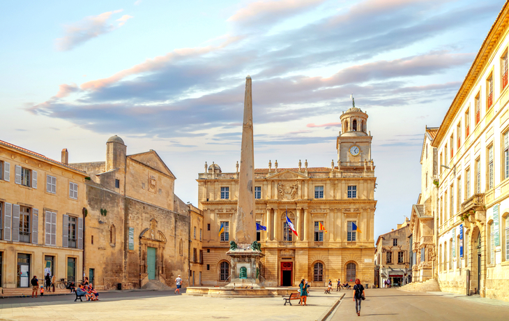 Historischer Platz mit Obelisk und alten Gebäuden bei Sonnenuntergang.