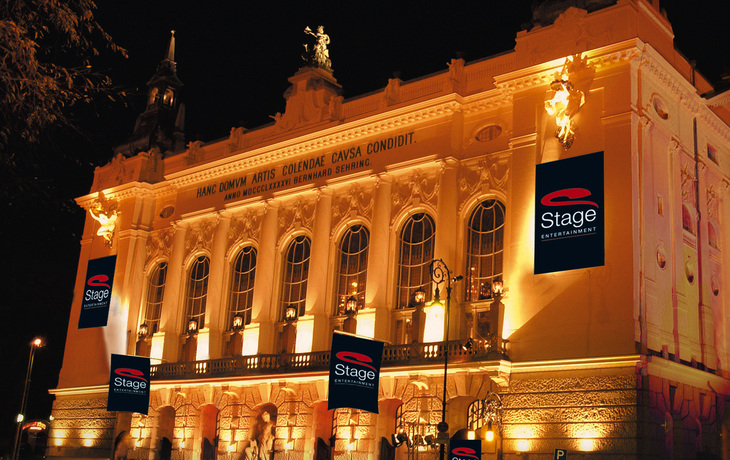 Beleuchtetes Gebäude mit Beschilderung von Stage Entertainment bei Nacht.