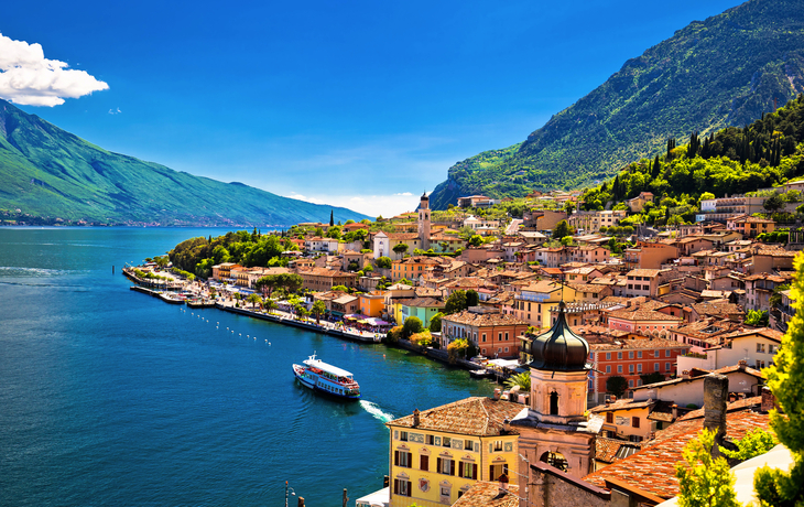 Blick auf Limone sul Garda am Gardasee mit Boot und Bergen im Hintergrund.