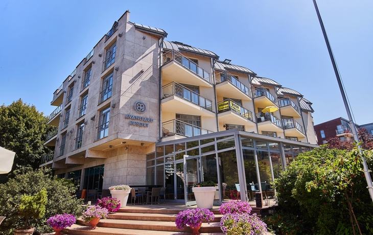 Moderne Gebäude-Fassade mit gläsernem Erdgeschoss und Pflanzen.