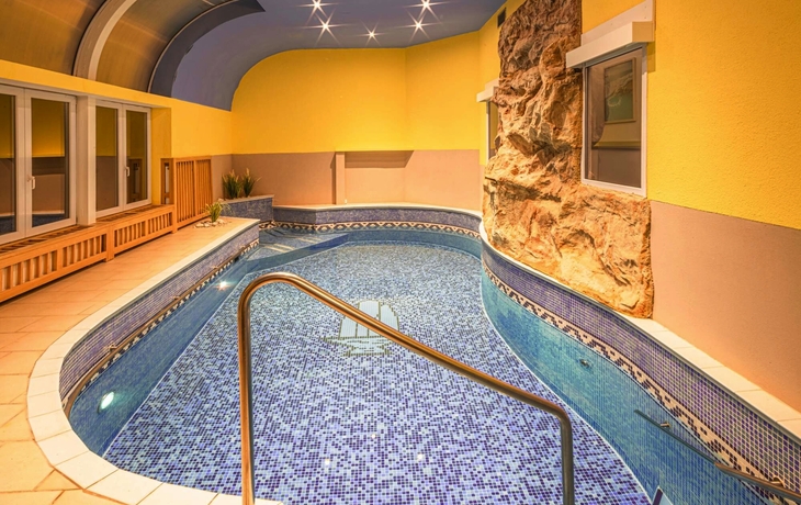 Innenpool mit blauen Mosaikfliesen und gelben Wänden im Hotel Richard in Marienbad.