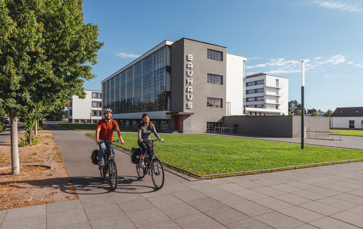 Zwei Radfahrer vor dem Bauhaus-Gebäude in Dessau.