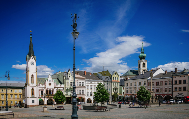 Rathaus und Gebäude am Krakonosovo-Platz in Trutnov bei klarem Himmel.