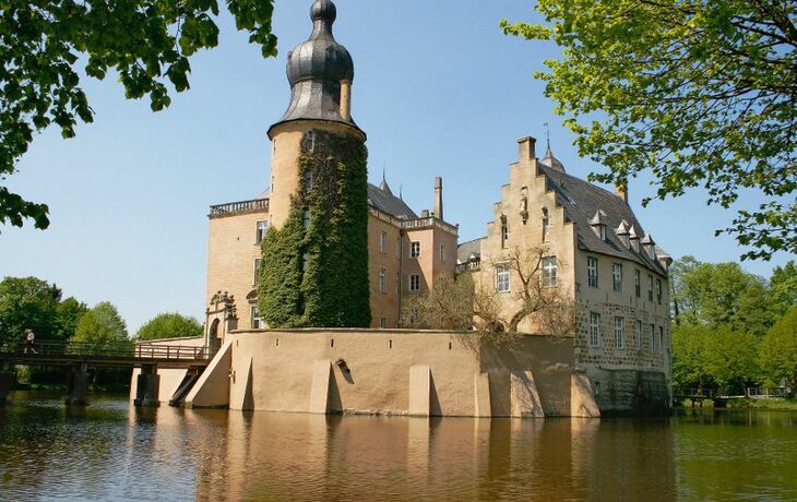 Jugendburg Gemen in NRW, umgeben von Wassergraben und Bäumen.