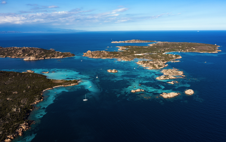 Luftaufnahme einer Küstenlinie mit Inseln und blauem Meer.