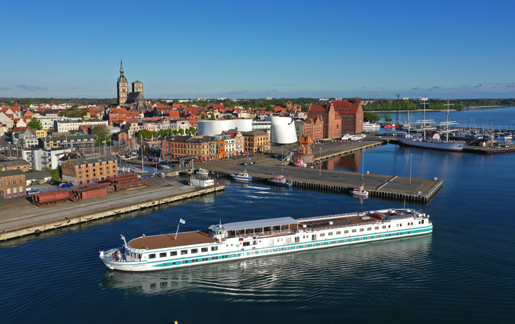 Kreuzfahrtschiff Junker Jörg vor dem Hafen von Stralsund überblickt von der historischen Altstadt.