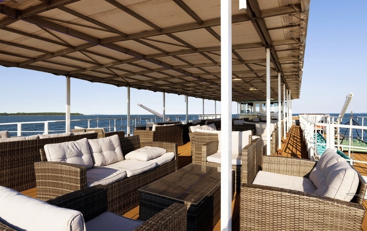 Sonnendeck mit Sitzgelegenheiten und Sicht auf das Wasser.