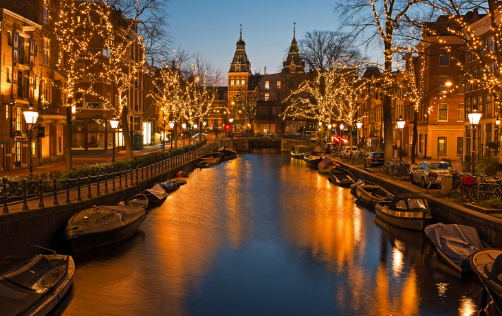Weihnachtlich beleuchteter Kanal in Amsterdam vor dem Rijksmuseum bei Nacht.