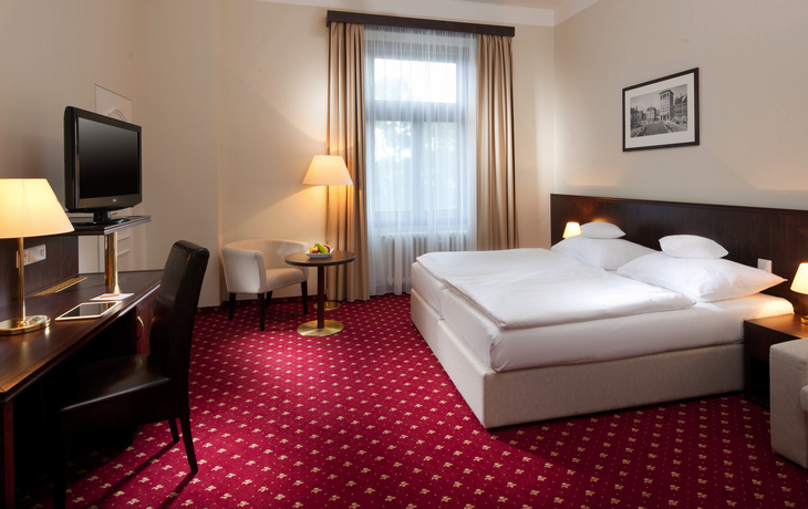 Hotelzimmer mit Doppelbett, Schreibtisch und Fernseher in Liberec.