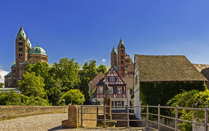Fachwerkhaus und Dom in der Altstadt bei Sonnenschein mit blauem Himmel.
