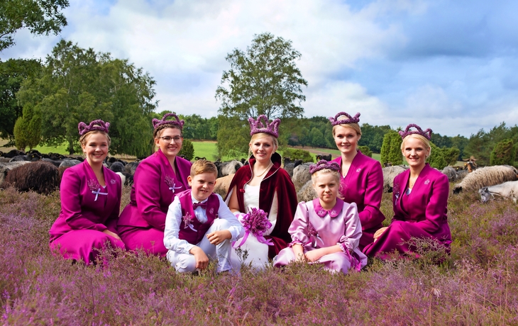 Gruppe in traditionellen Kostümen auf einer Heidefläche