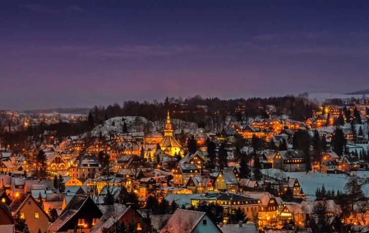 Winterliche Nachtansicht von Seiffen im Erzgebirge, beleuchtet zur Adventszeit.