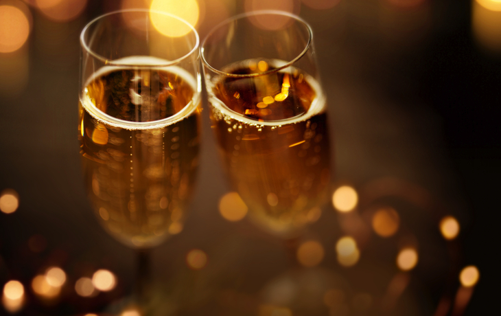 Zwei gefüllte Sektgläser mit unscharfem Bokeh-Hintergrund.