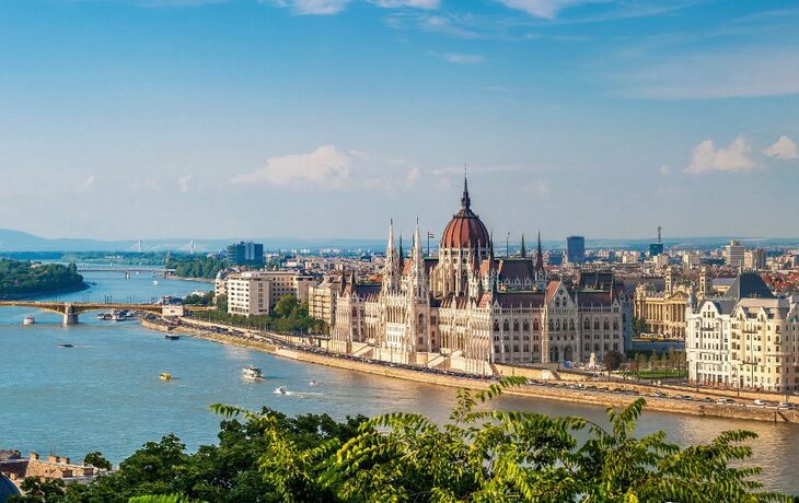 Blick auf das ungarische Parlament und die Donau bei sonnigem Wetter.