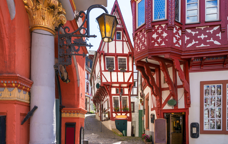 Fachwerkhäuser in einer engen, malerischen Altstadtgasse bei Tageslicht.