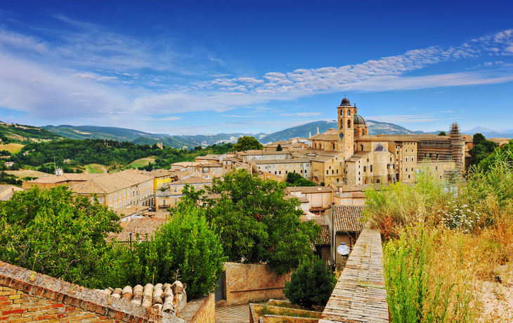 Blick auf die mittelalterliche Stadt Urbino mit historischen Gebäuden und Türmen.