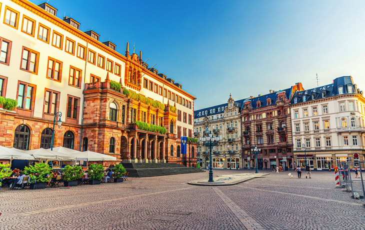 Wiesbadens Stadtschloss bei sonnigem Wetter, umgeben von historischen Gebäuden.