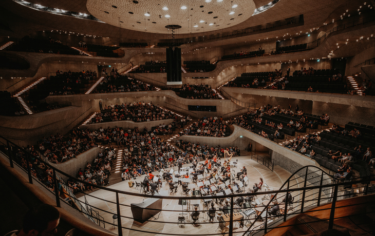 Orchester spielt vor Publikum im Konzertsaal der Elbphilharmonie.
