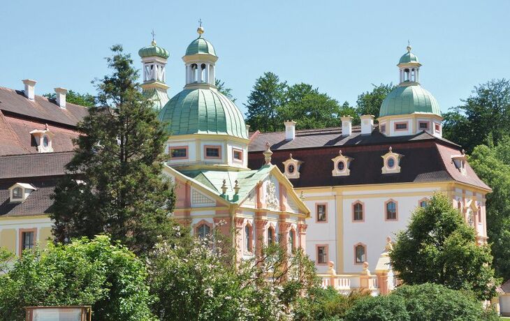 Kloster Marienthal in Ostritz mit Kuppeln und Türmen, umgeben von Bäumen und Büschen.