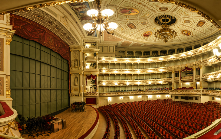 Innenansicht der Semperoper in Dresden mit Zuschauerrängen und Bühnenbereich.
