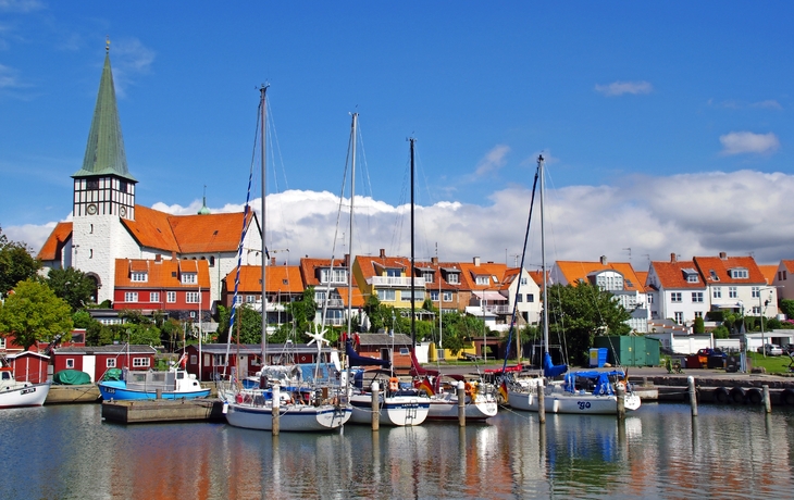 Segelboote im Hafen von Rønne, Bornholm, mit Altstadt und Kirchturm im Hintergrund.