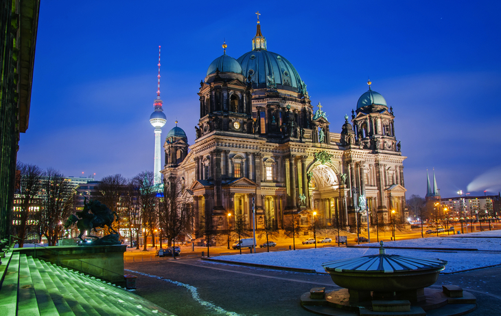 Berliner Dom bei Dämmerung mit Fernsehturm im Hintergrund.