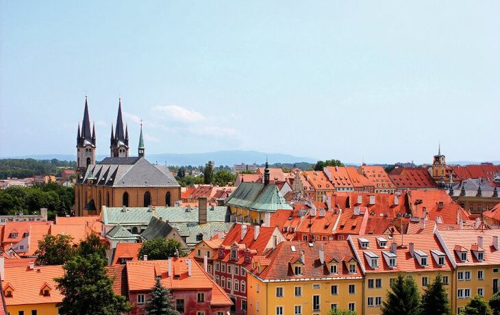 Blick über die Dächer von Cheb mit einer Kirche im Hintergrund.