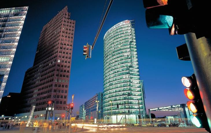 Potsdamer Platz bei Nacht mit Hochhäusern und Verkehrsampeln.