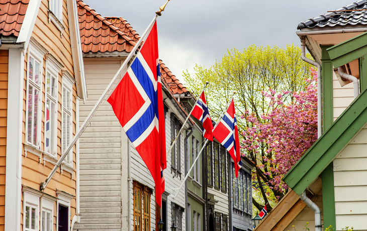 Bunte Holzhäuser mit norwegischen Flaggen in Bergen, Norwegen.