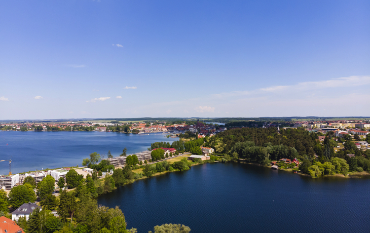 Luftaufnahme der Binnenmüritz in Waren an der Müritz, umgeben von Wald und Gebäuden.