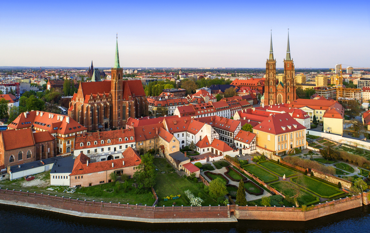 Luftaufnahme einer historischen Stadt mit Kirchen und alten Gebäuden am Fluss.