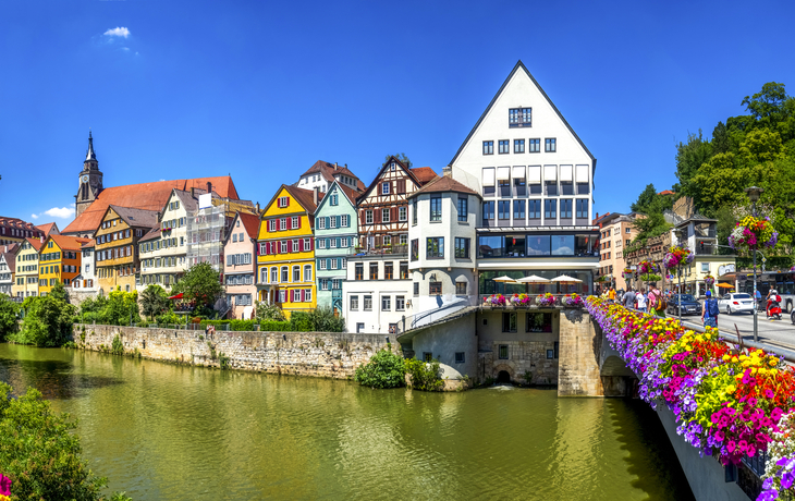 Hölderlinturm in Tübingen am Neckar mit bunten Fachwerkhäusern im Hintergrund.